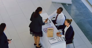 Businesswoman checking in at conference registration table 4k