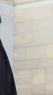 Vertical video: Turning grad cap, gown tassel as friend coming left on campus hugging celebrating
