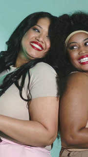 Vertical video: Posing two women on cue, adjusting with teal backdrop in beige for portrait shoot