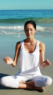 Woman performing yoga at beach