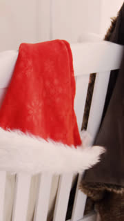 Santa hat and christmas decoration hanging on chair