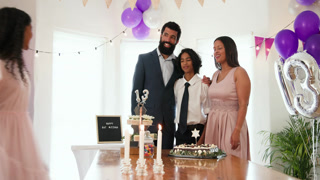 diverse family celebrating traditional ceremony, embracing and lighting candles at home