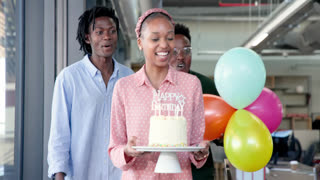 African American coworkers celebrating birthday in modern office, sharing cake and clapping
