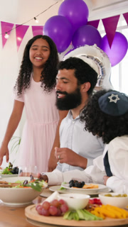 Vertical video: Girl entering father hugging her and toasting juice with son at dining table