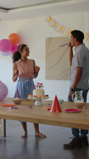 Vertical video: Spotting birthday banner, diverse couple decorating table, sharing sparkler joy