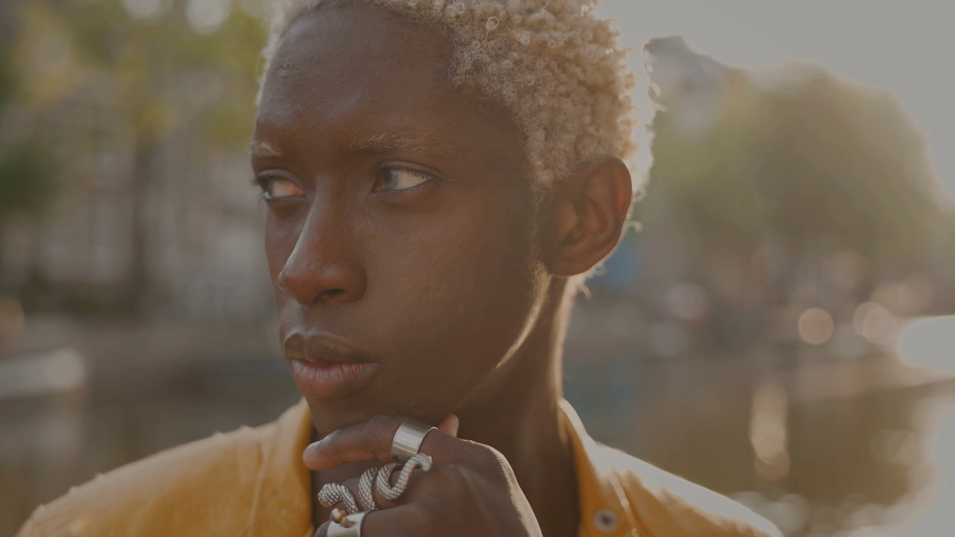 Portrait Of Young Black Boy With White Dyed Hair Behind Him Is Canal  portrait-of-young-black-boy-with-white-dyed-hair-behind-him-is-canal