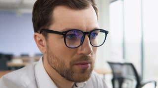 Businessman with glasses looks at stock market quotes and exchange rates during the financial crisis