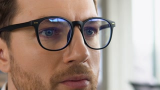 Businessman with glasses looks at stock market quotes and exchange rates during the financial crisis