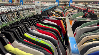 A rack of kid's and teen boy's T-shirts in bright colors and prints is displayed in the youth clothing section. Different sizes and styles