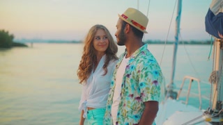 Guy with the girl meets a sunset on the yacht. Lovers relaxing on the yacht. Honeymoon. Cruise around the world.