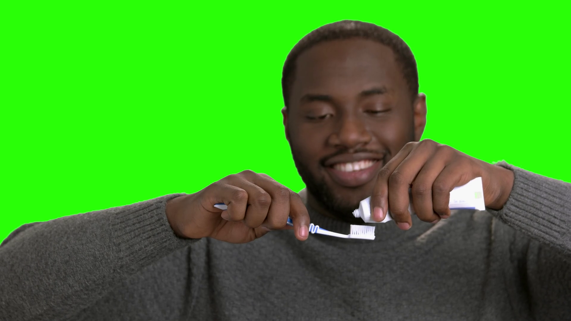 African American guy putting toothpaste on his toothbrush. Smiling darkskinned man applying