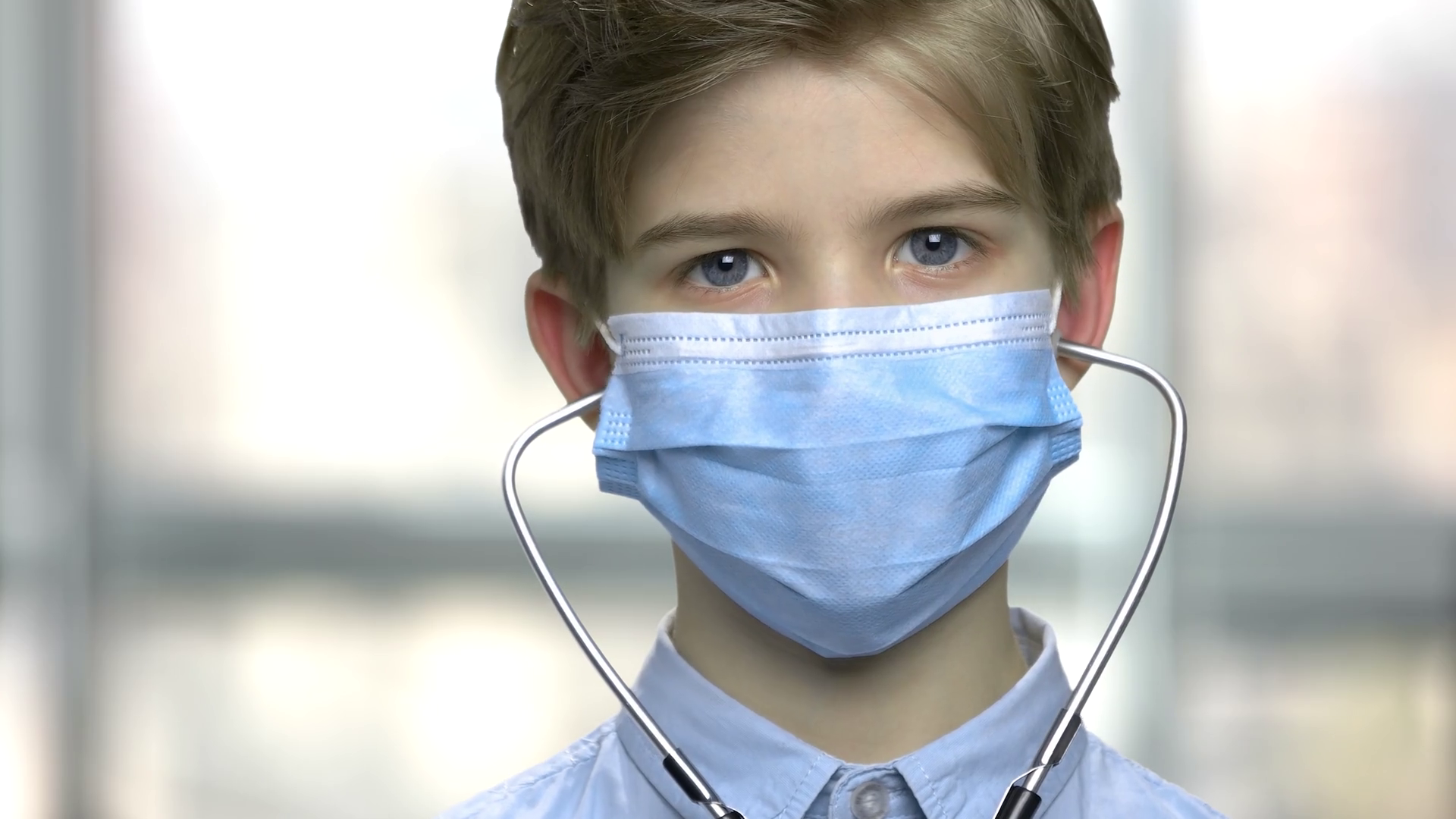 Boy in blue medical mask. Caucasian child wearing protective face mask