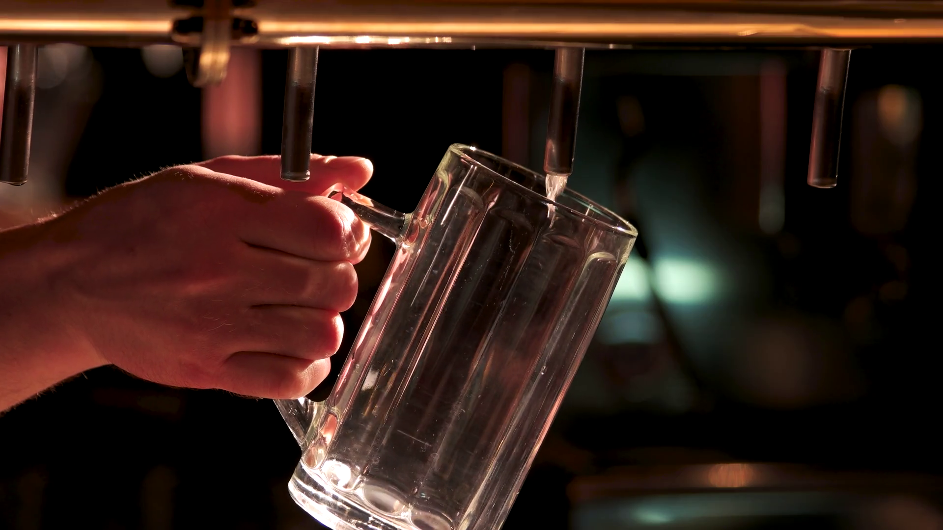 Closeup filling beer from beer pump. Barman hand pouring a lager beer