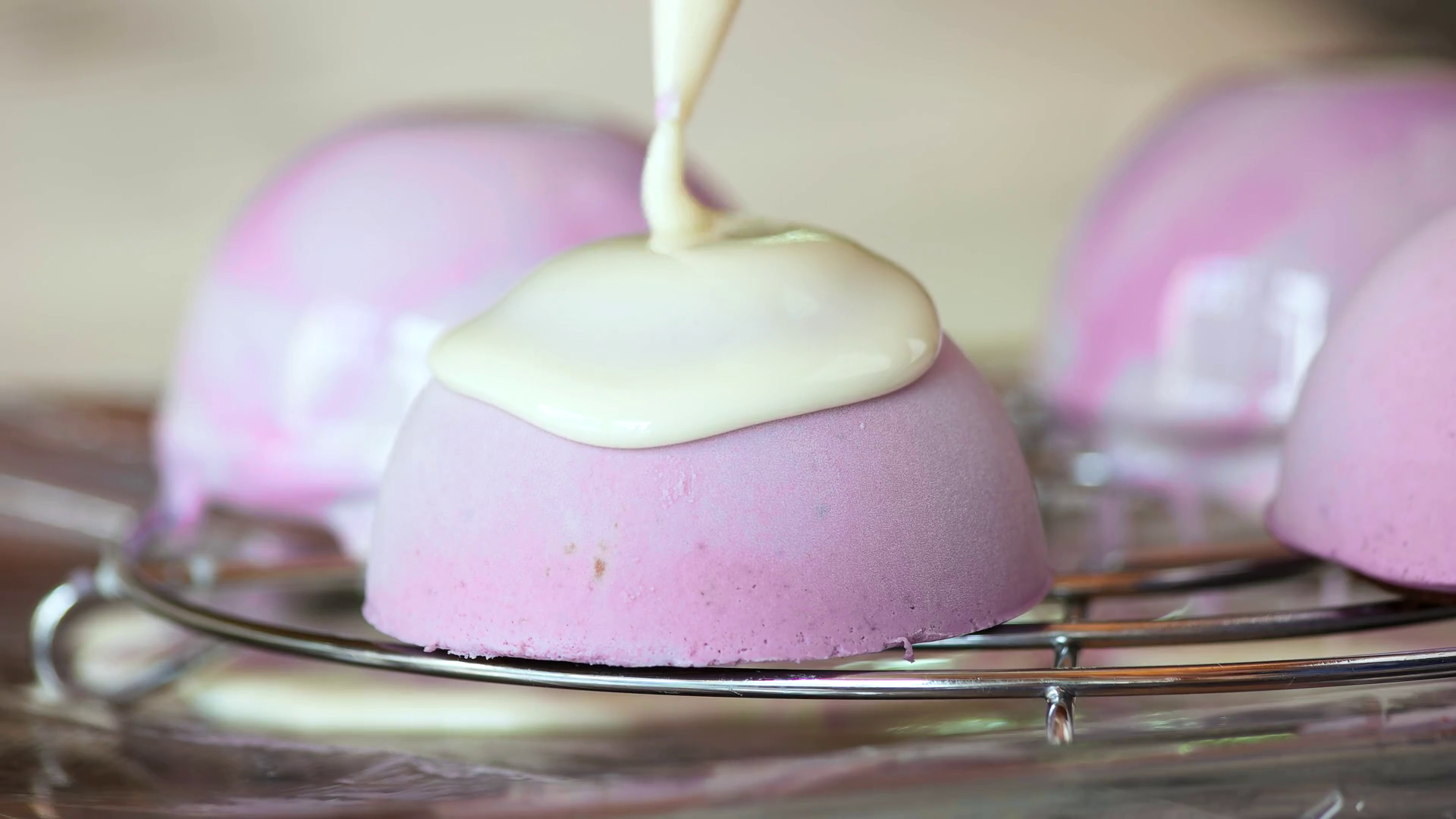 Covering dome shaped cake with liquid glaze. Preparing french mousse
