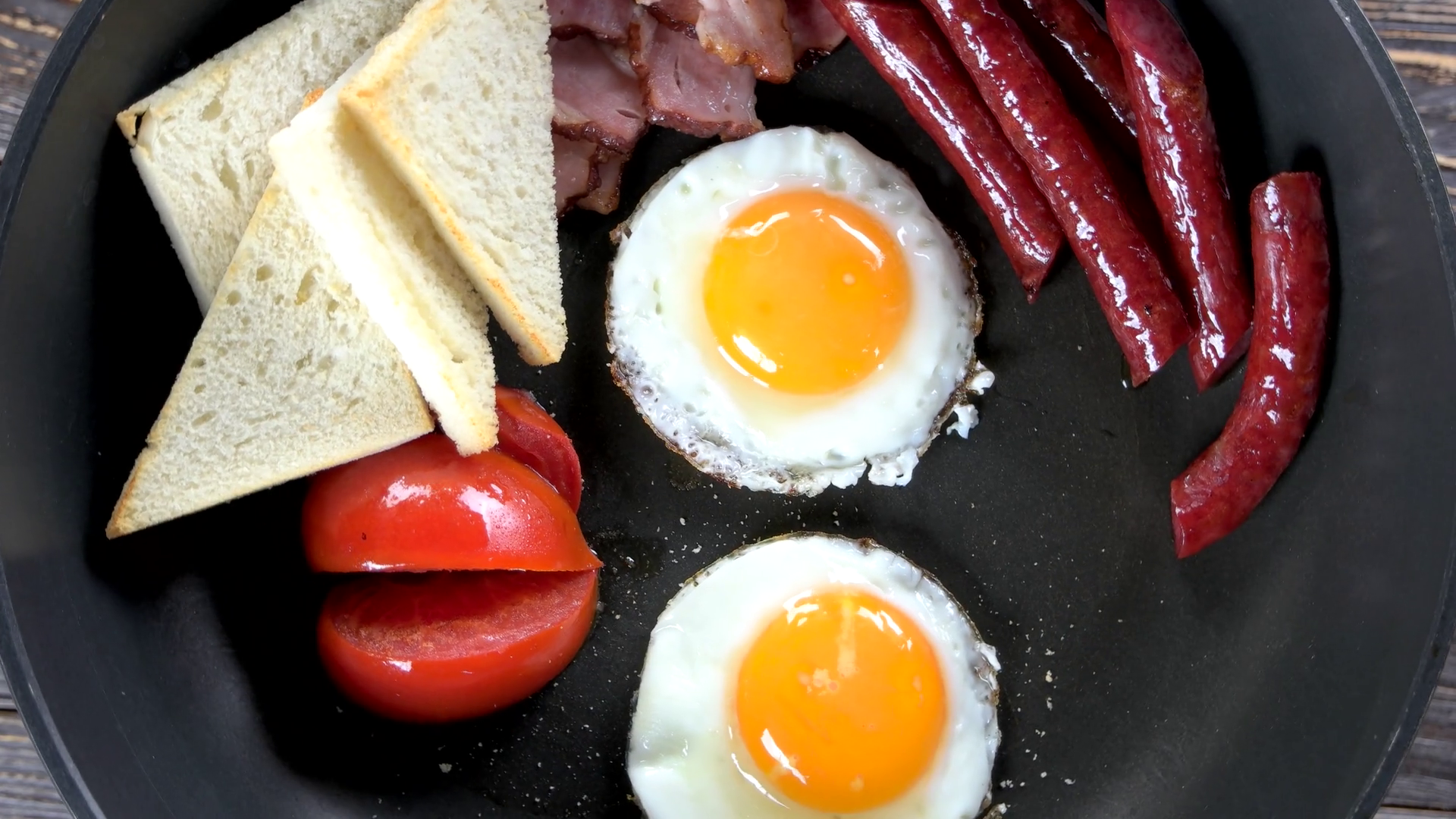 Fried eggs, sausages and tomato. Traditional English breakfast. Stock
