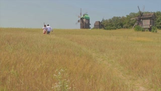 In love couple runs in the field. A date in nature. Guy and girl having fun running along a path in the field. Meeting lovers. Happy couple. Romantic date.