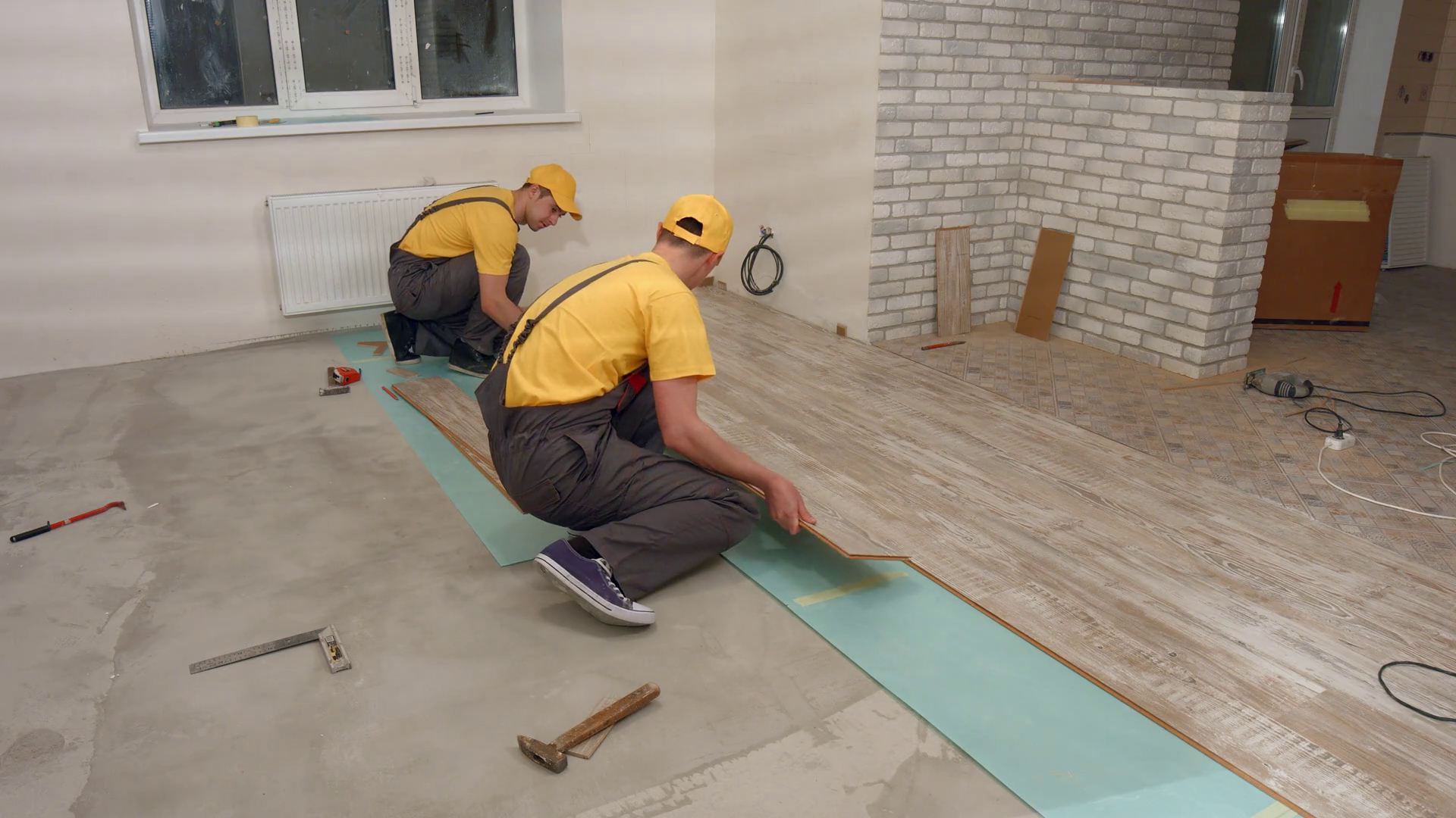 Laying floorboard. Team of builders make renovation of apartment