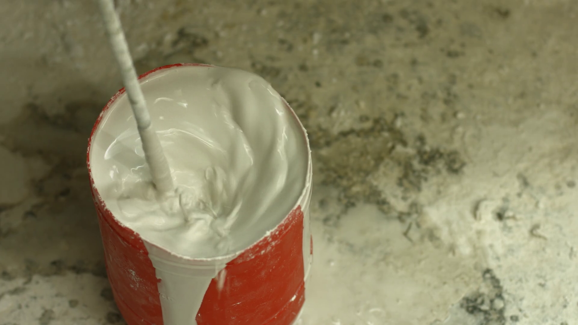 Mixing liquid gypsum. Electric appliance mixes liquid material. Liquid white gypsum in container