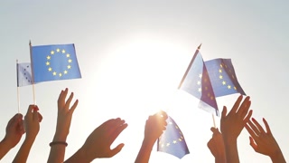 People with raised hands waving flags of the European Union. European dream. Future of Europe. European flag. Fans from Europe rooting for their team.