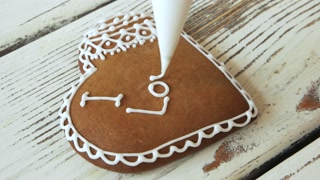 Valentines Day cookie decoration. Piping an inscription I love you on gingerbread cookie. Love and romance concept.