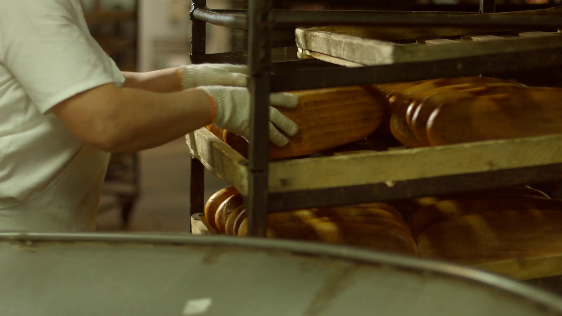 Worker of bakery factories takes bread from the conveyor. Baking bread
