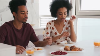 Concentrated african couple having breakfast in the morning