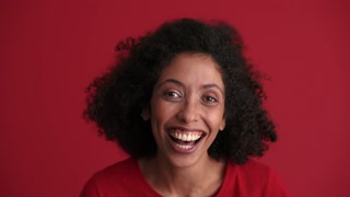 Laughing African woman looking at the camera in the red studio