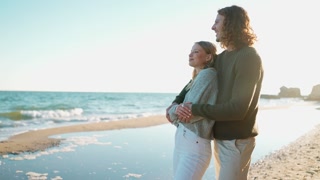 Nice couple hugging and talking near beach by sea