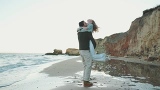 Nice couple twirling on beach near sea
