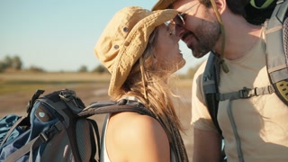 Close-up view of smiling tourist couple kissing near the river