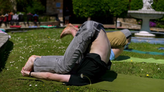 Group practicing yoga pose in a sunny park