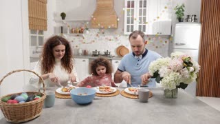 Loving parents and their cute daughter enjoying festive meal at home