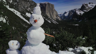 Familyoriented winter tableau showcasing handmade snowman with Yosemite background