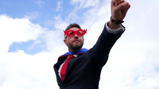 businessman in superhero suit flying with raised hand, business success