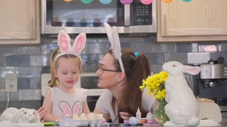 A mother happily spends time with her daughter in her cozy kitchen, filling the with creativity and festive spirit. A sincere celebration of