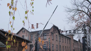 Snow falling on the arbeit macht frei gate at the entrance of the auschwitz camp in poland