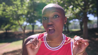 Playful african american woman with a buzz cut making funny faces and sending kisses at the camera