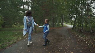 Mother and son walking in the autumn park
