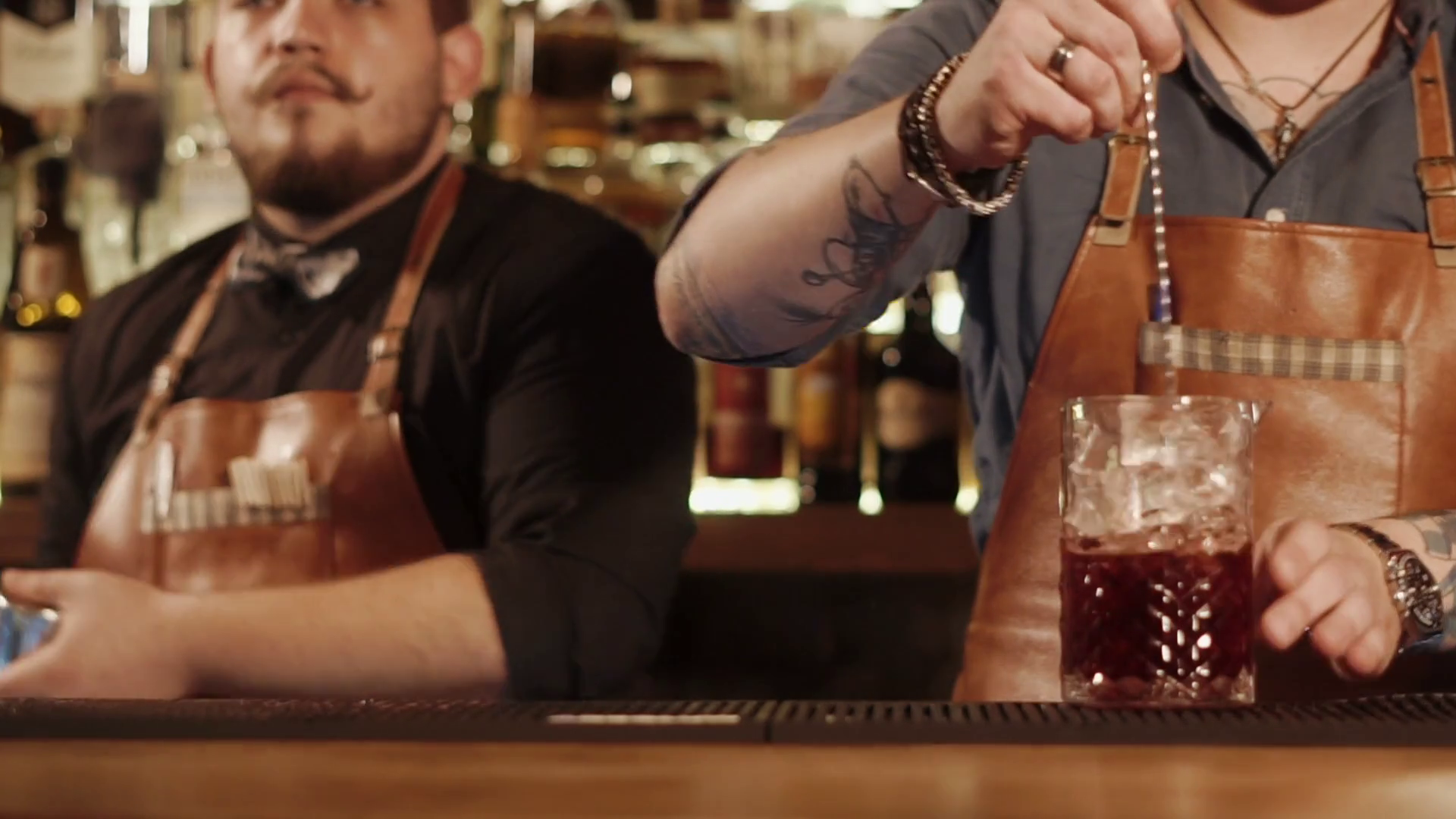 Barmans Are Working Behind Bar Rack One Man Is Shaking Mixed Drinks In
