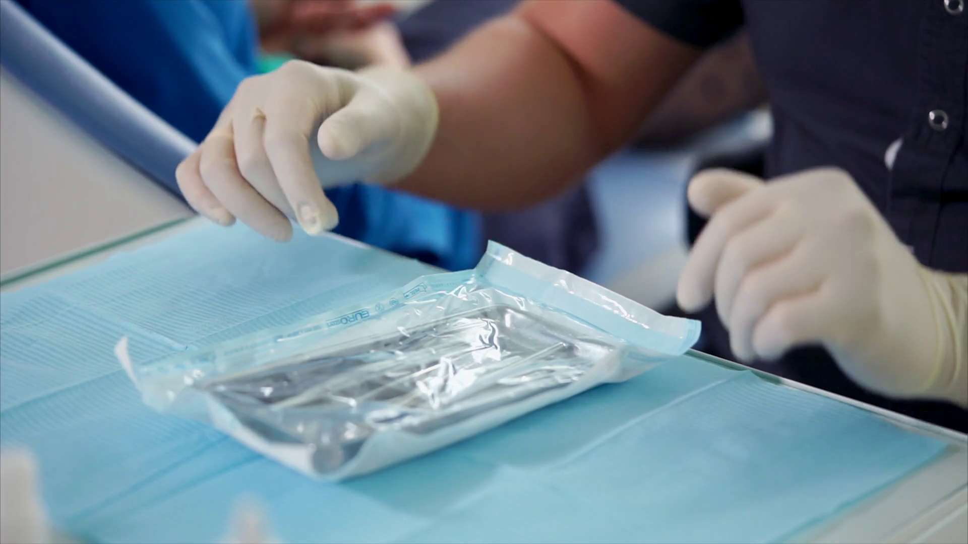 Dentist preparing to examine the patient. He opening the package with