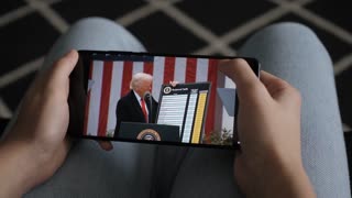 President Trump Trump Announces Tariffs In White House 2 April. Person Watches US President Donald Trump's Speech at White House on His Mobile Phone. Greer, SC, USA - August 03, 2025.