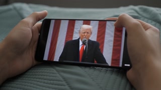 Person Watches US President Donald Trump's Speech at White House on His Mobile Phone. President Trump Holds "Make America Wealthy Again Event" In White House. Greer, SC, USA - August 03, 2025.