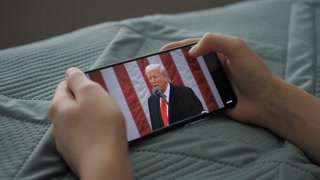 Person Watches US President Donald Trump's Speech at White House on His Mobile Phone. President Trump Holds "Make America Wealthy Again Event" In White House. Greer, SC, USA - August 03, 2025.