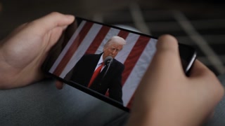 Person Watches US President Donald Trump's Speech at White House on His Mobile Phone. President Trump Holds "Make America Wealthy Again Event" In White House. Greer, SC, USA - August 03, 2025.