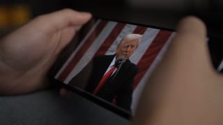 Person Watches US President Donald Trump's Speech at White House on His Mobile Phone. President Trump Holds "Make America Wealthy Again Event" In White House. Greer, SC, USA - August 03, 2025.