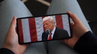 Person Watches US President Donald Trump's Speech at White House on His Mobile Phone, Digital Tablet. President Trump Make America Wealthy Again In White House. Greer, SC, USA - November 5, 2025.
