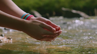 Female Hand Touching River Flow. Hands With Pure Spring Water. Crystal Clear Mountain Water. Relax Refresh Peaceful in Nature. Slow Motion Woman's Hand Scoops Water From Stream in Forest.