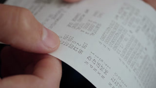 Inflation Economy. Close-up Receipt Person Hands of Shopper Reading Accounting Report After Buying or Purchase Credit. Till Slip Man Holding Finance Document After Buying or Shopping in Supermarket.