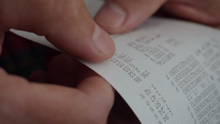 Inflation Economy. Close-up Receipt Person Hands of Shopper Reading Accounting Report After Buying or Purchase Credit. Till Slip Man Holding Finance Document After Buying or Shopping in Supermarket.
