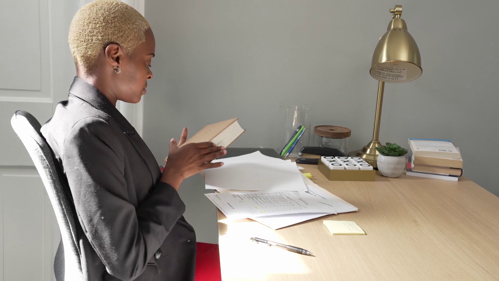 Black woman at her law office opening up legal text Stock Video Footage